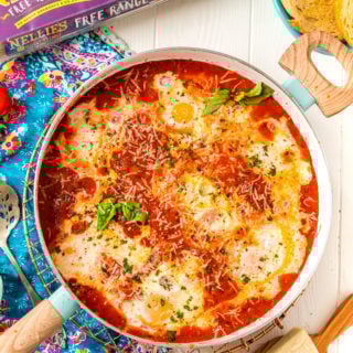 Overhead photo of Eggs In Purgatory in a skillet with additional ingredients scattered around it.