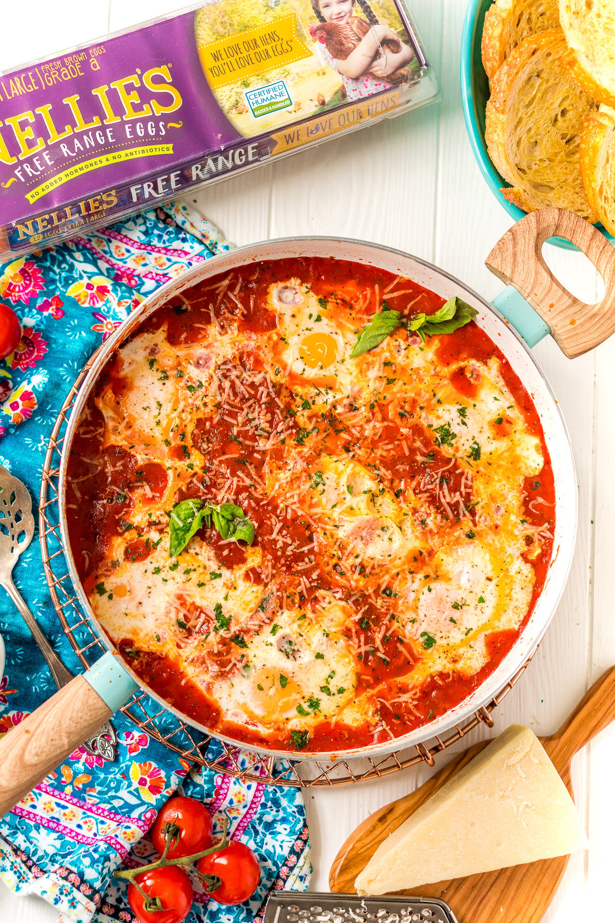 Overhead photo of Eggs In Purgatory in a skillet with additional ingredients scattered around it.