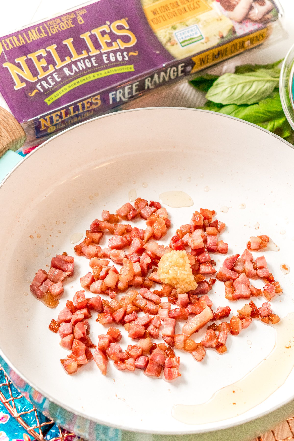 Pancetta and garlic being sauteed in a skillet.