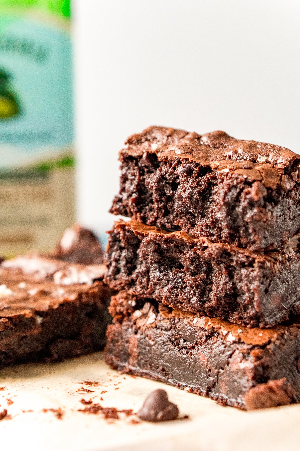 Stack of three olive oil brownies with a bottle of olive oil in the background.