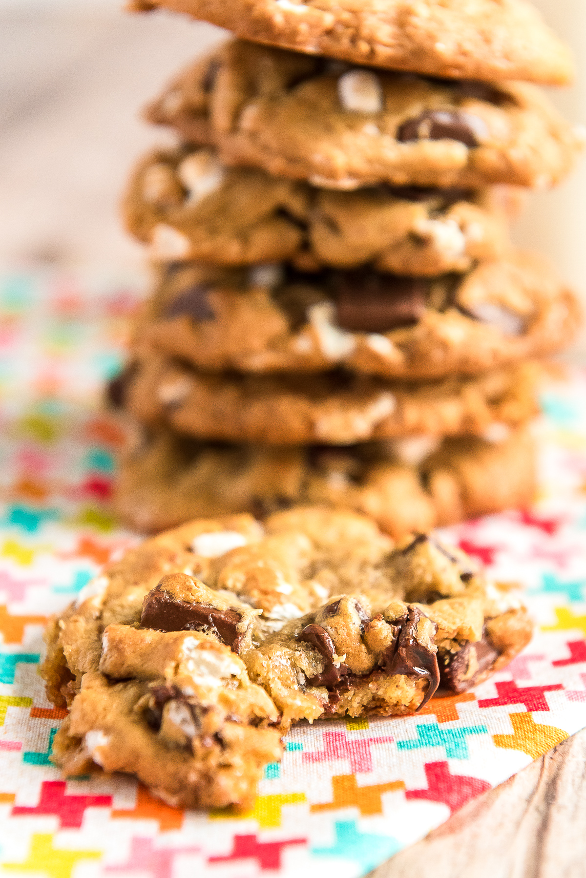 Stack of cookies with one cookie in the foreground with a bite taken out of it.