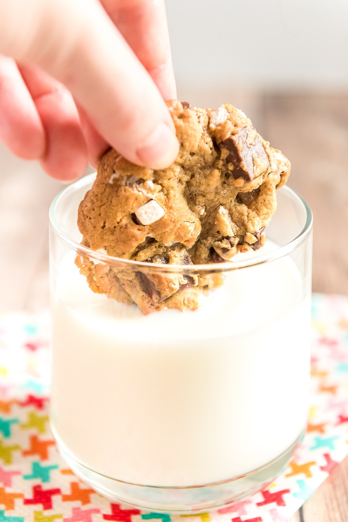 S'mores cookie being dunked in a glass of milk.