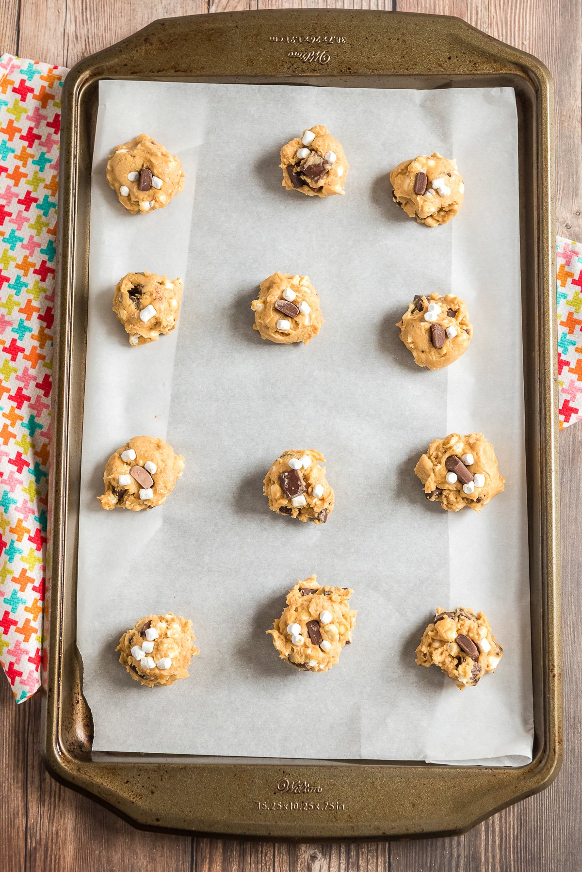 Cookie dough balls on a parchment lined cookie sheet.