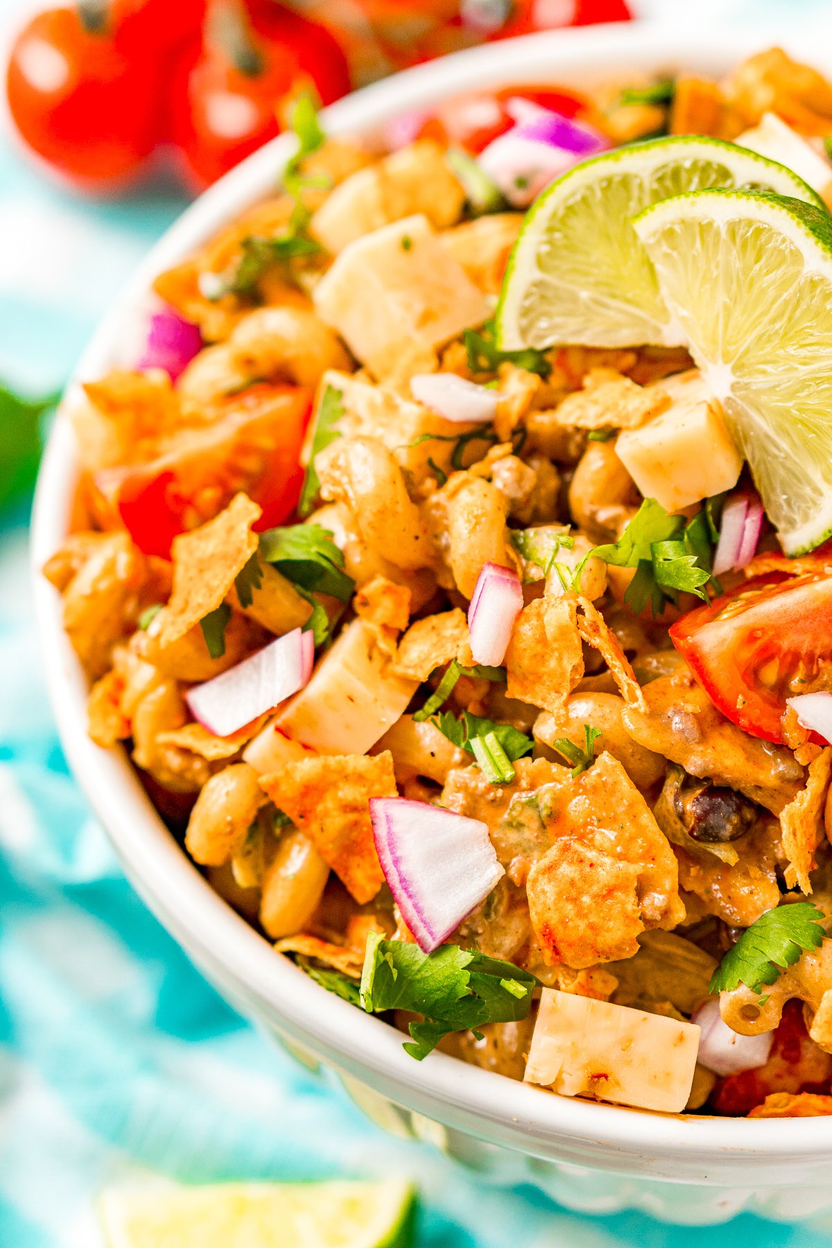 Pasta salad with taco fixings in a large white bowl for serving.