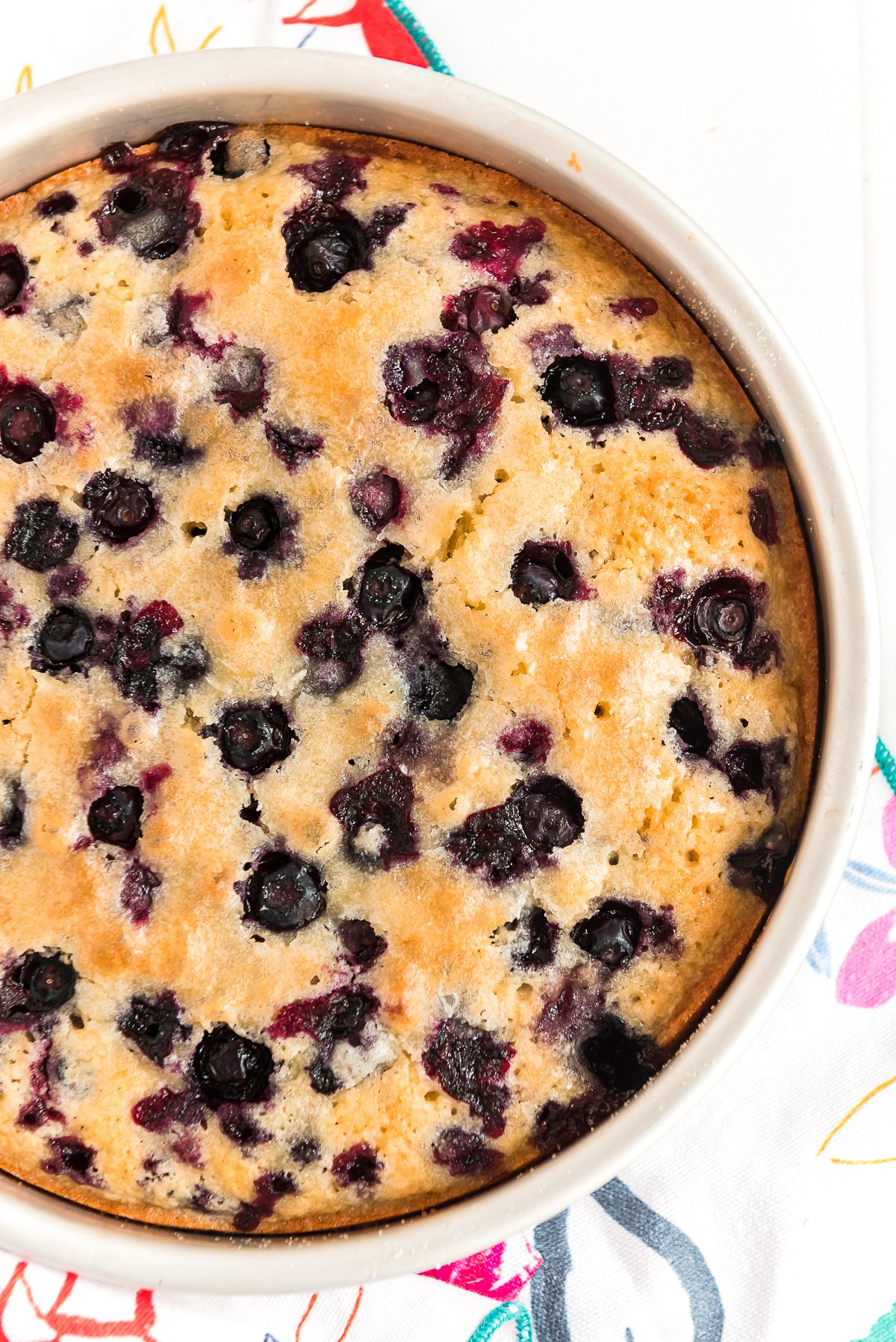 Overhead shot of a blueberry cake in a round baking pan.