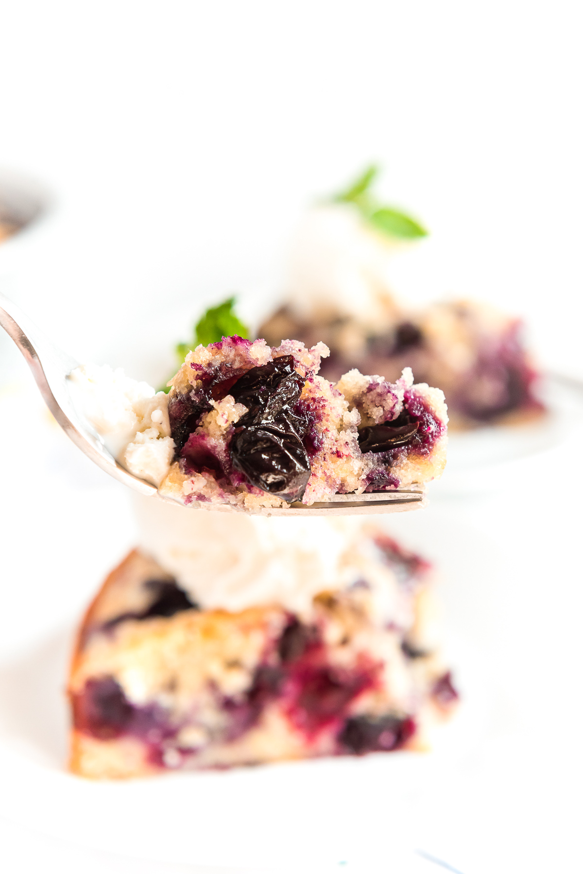 Bite of blueberry cake on a fork.