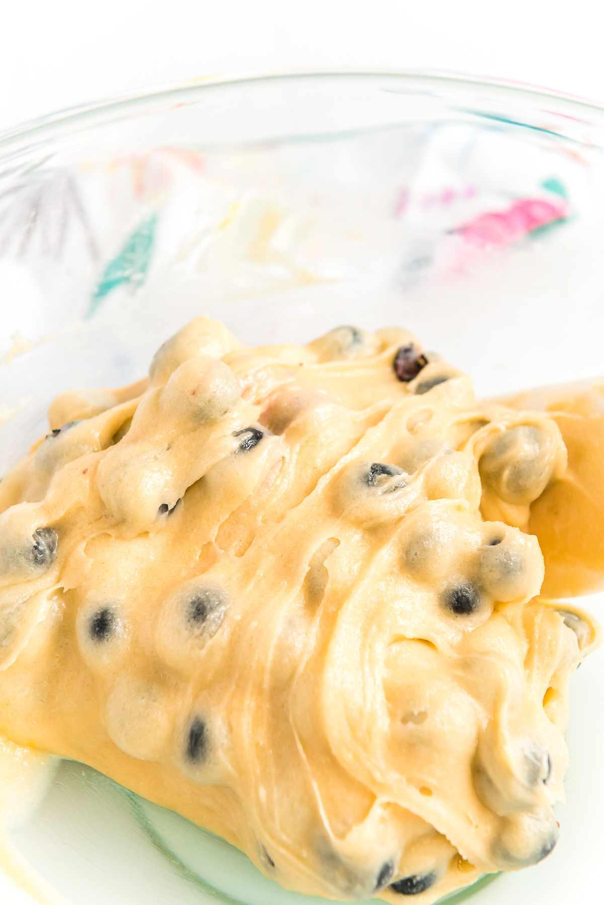 Blueberries being folded into cake batter to make blueberry cake.