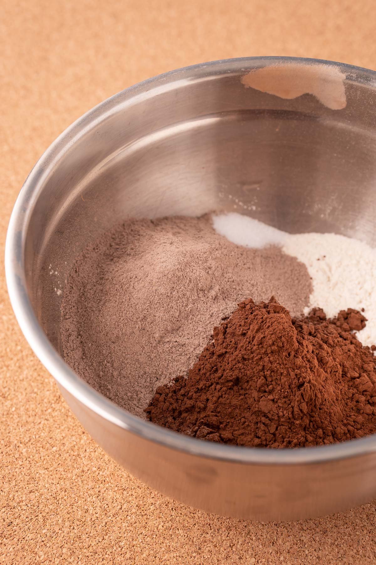Flour, cocoa, and pudding mix in a metal mixing bowl.