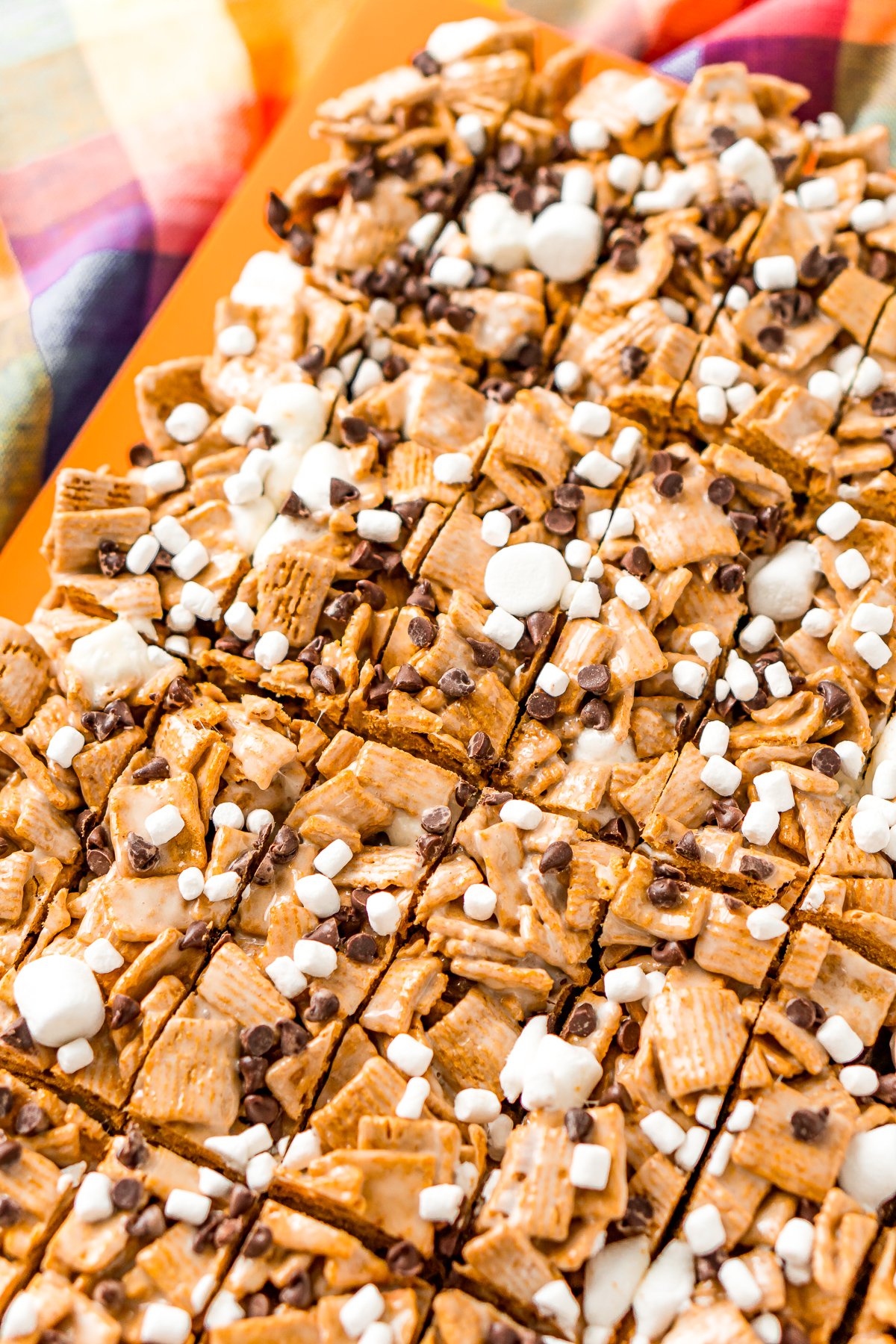 Sheet of s'mores bars that have recently been slice on a cutting board.