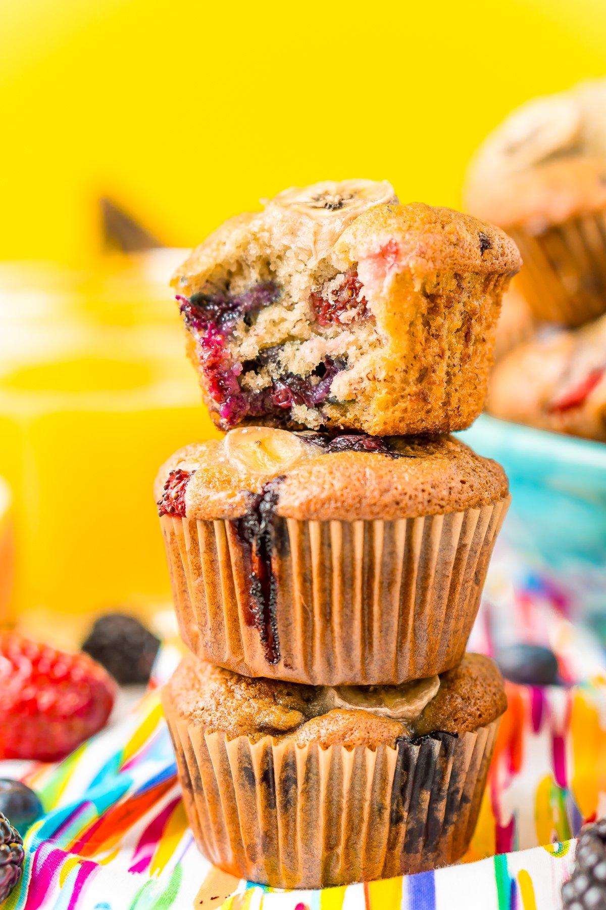 Stack of three muffins with a bite taken out of the top one.