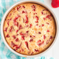 Overhead photo of baked strawberry cake on a blue napkin.