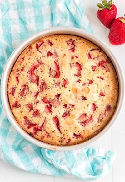 Overhead photo of baked strawberry cake on a blue napkin.