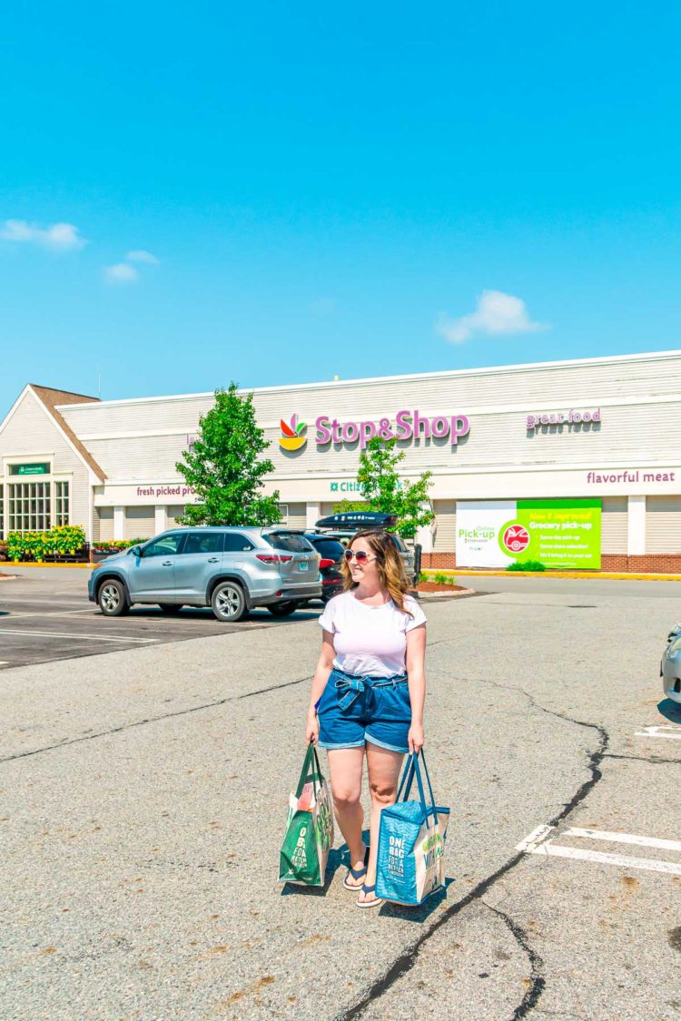 Woman carrying grocery bags out of a Stop & Shop grocery store.