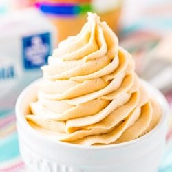 Close up photo of peanut butter cream cheese frosting piped into a small white bowl.