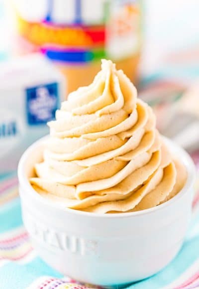 Close up photo of peanut butter cream cheese frosting piped into a small white bowl.