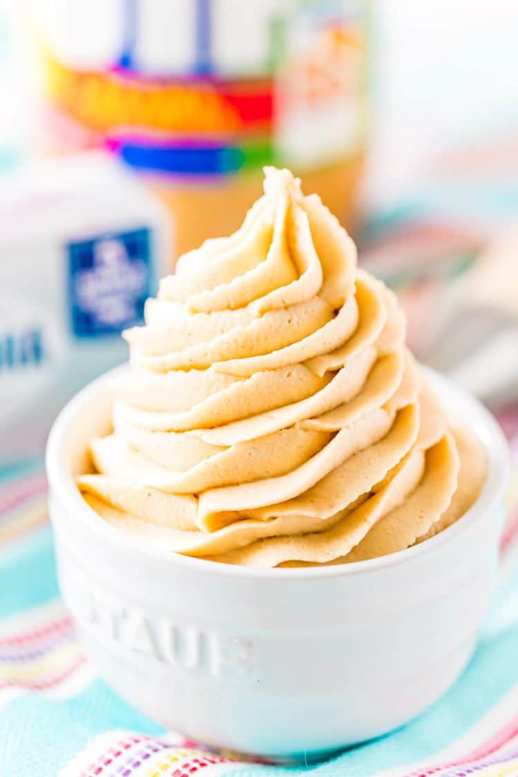 Close up photo of peanut butter cream cheese frosting piped into a small white bowl.