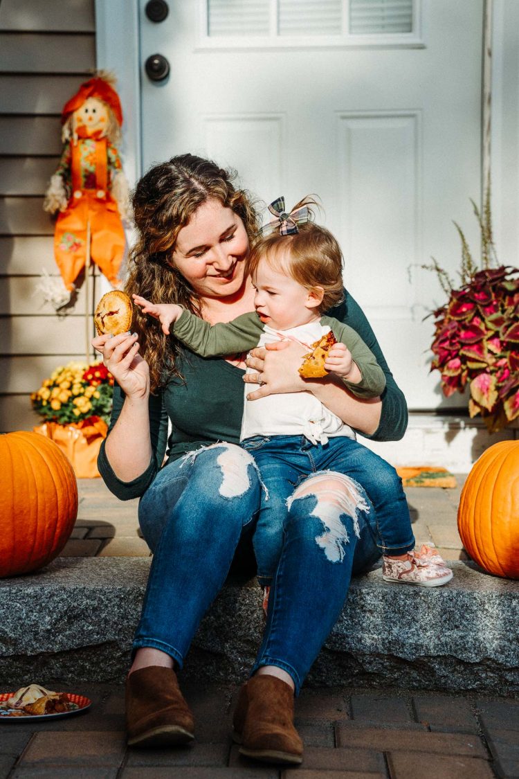 Mother and toddler daughter eating pie on patio steps.