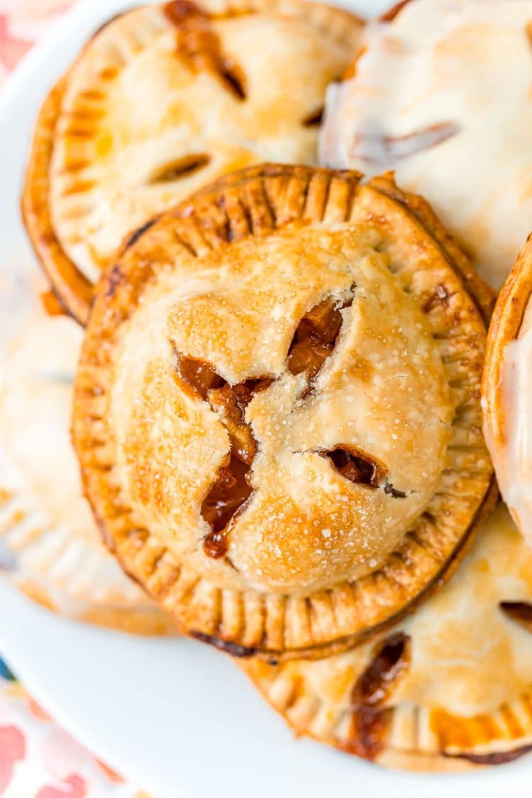 A white plate filled with apple hand pies.