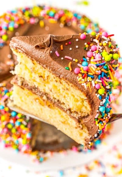 Slice of yellow layer cake being lifted with a cake server from the cake.