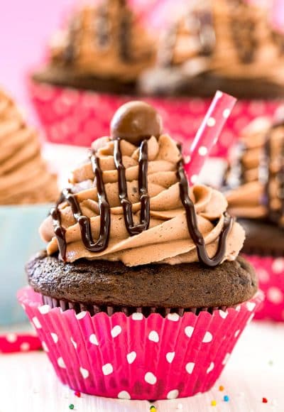 Close up photo of a chocolate milkshake cupcake with more cupcakes behind it.