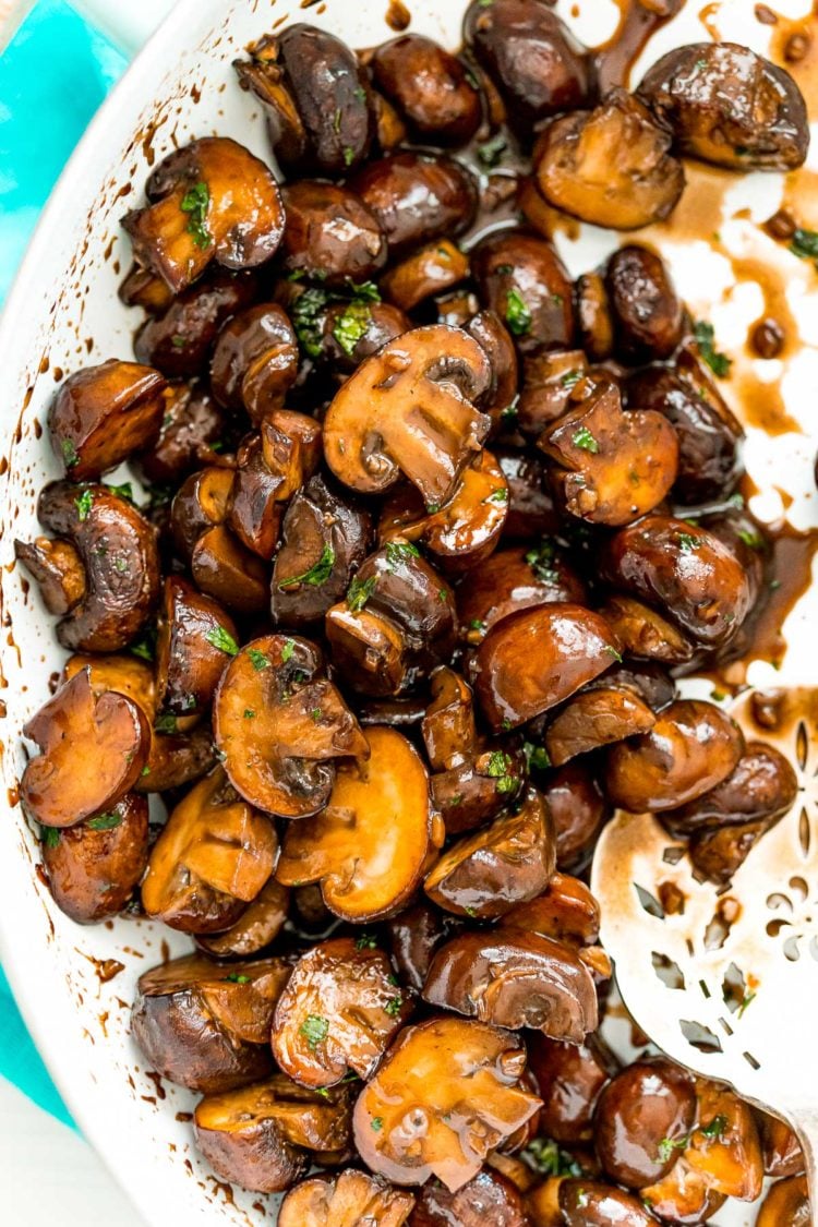 Ovehead photo of sauteed mushrooms in a white skillet.