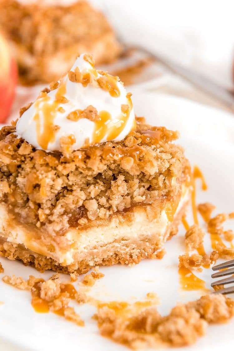 Slice of caramel apple cheesecake with a bite taken out of it.