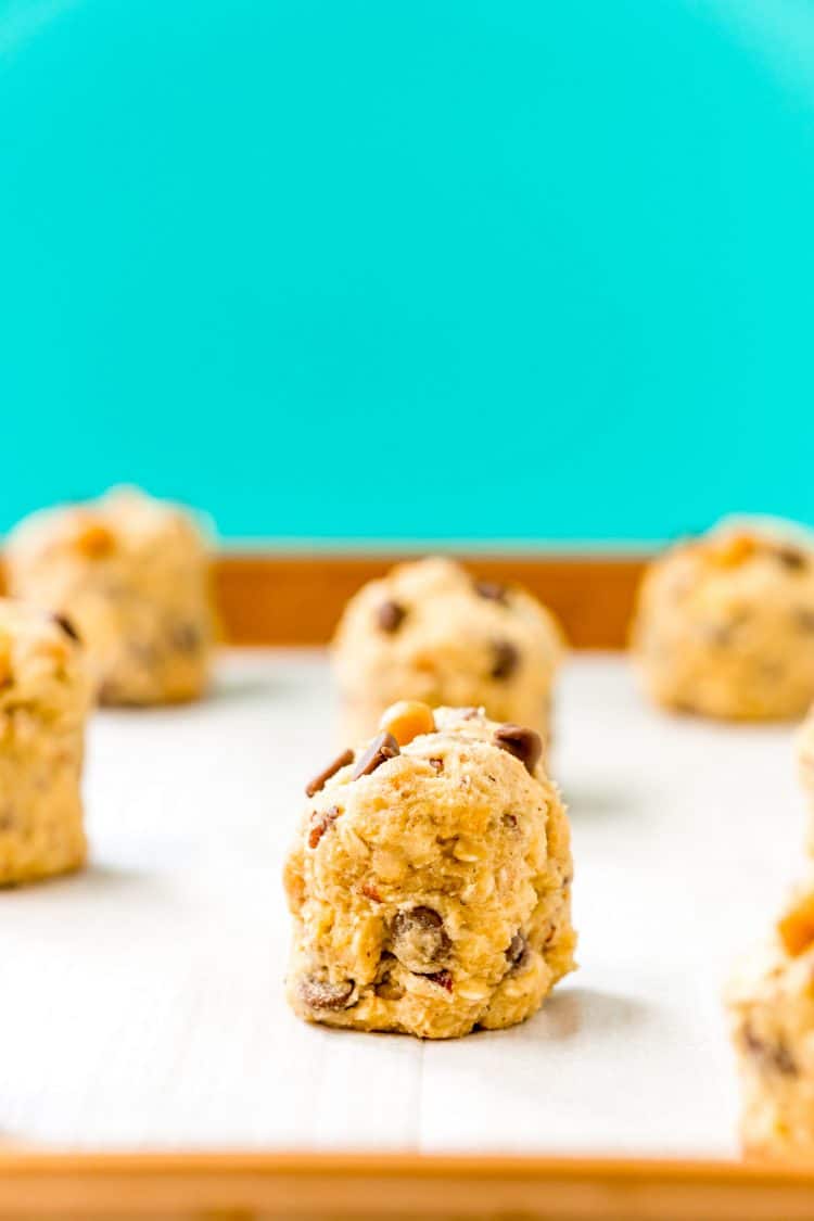 Raw cookie dough balls on a baking sheet ready to be baked.