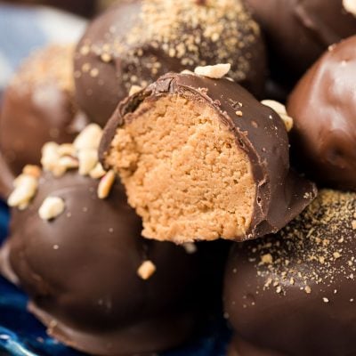 Chocolate dipped peanut butter balls on a blue plate.