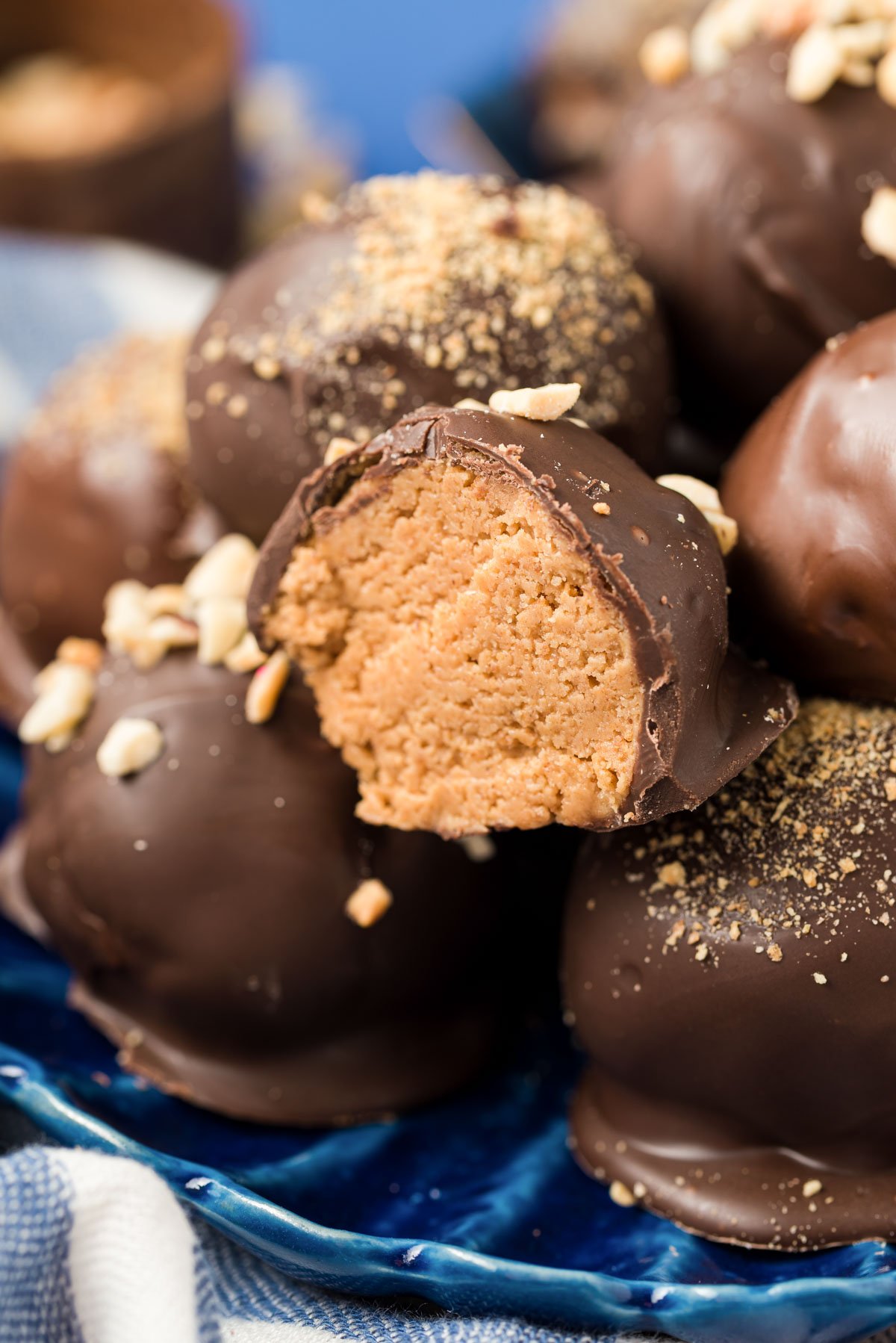 Chocolate dipped peanut butter balls on a blue plate.