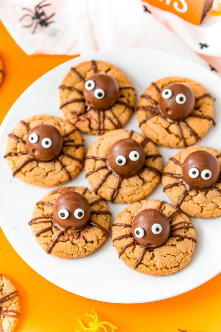Halloween spider cookies on a white plate to serve at a party.