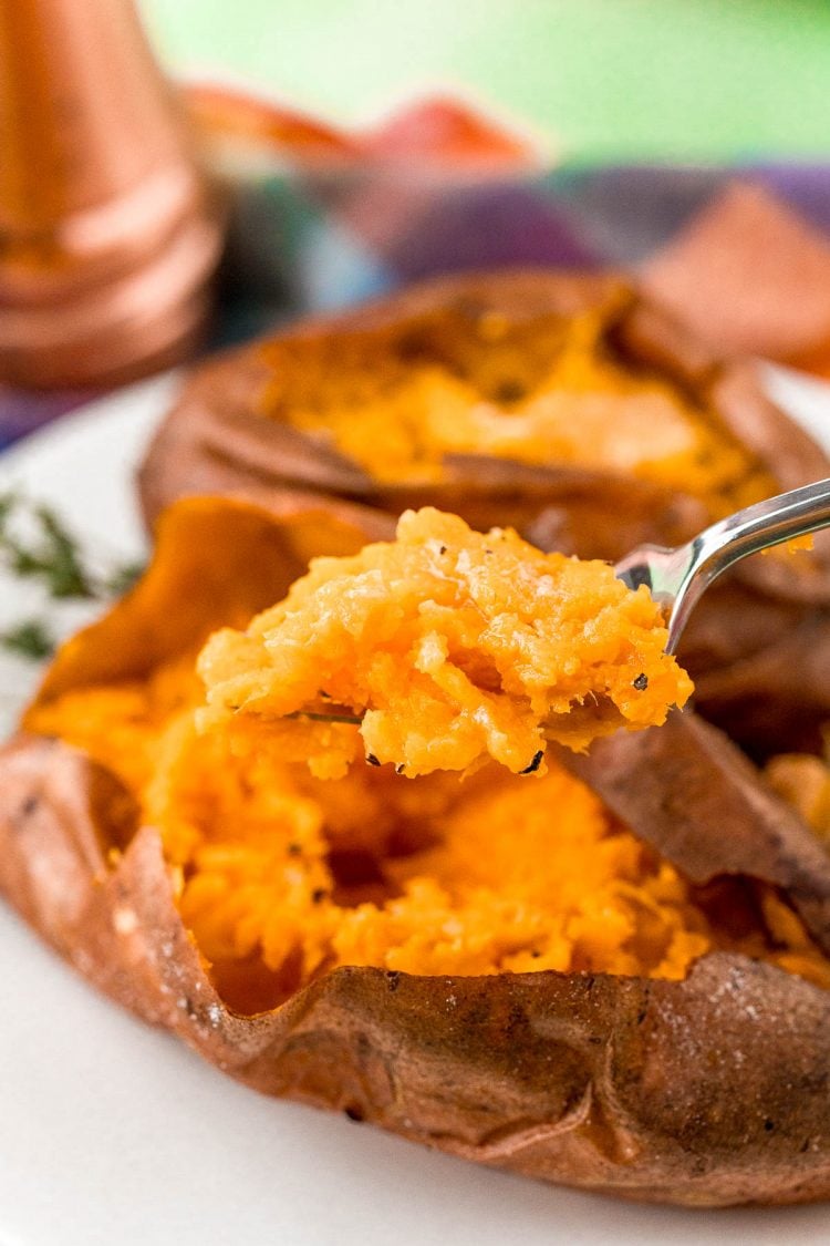 A fork full of baked sweet potato.