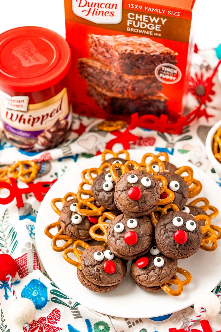 A plate of reindeer cookies with brownies mix and frosting in the background.