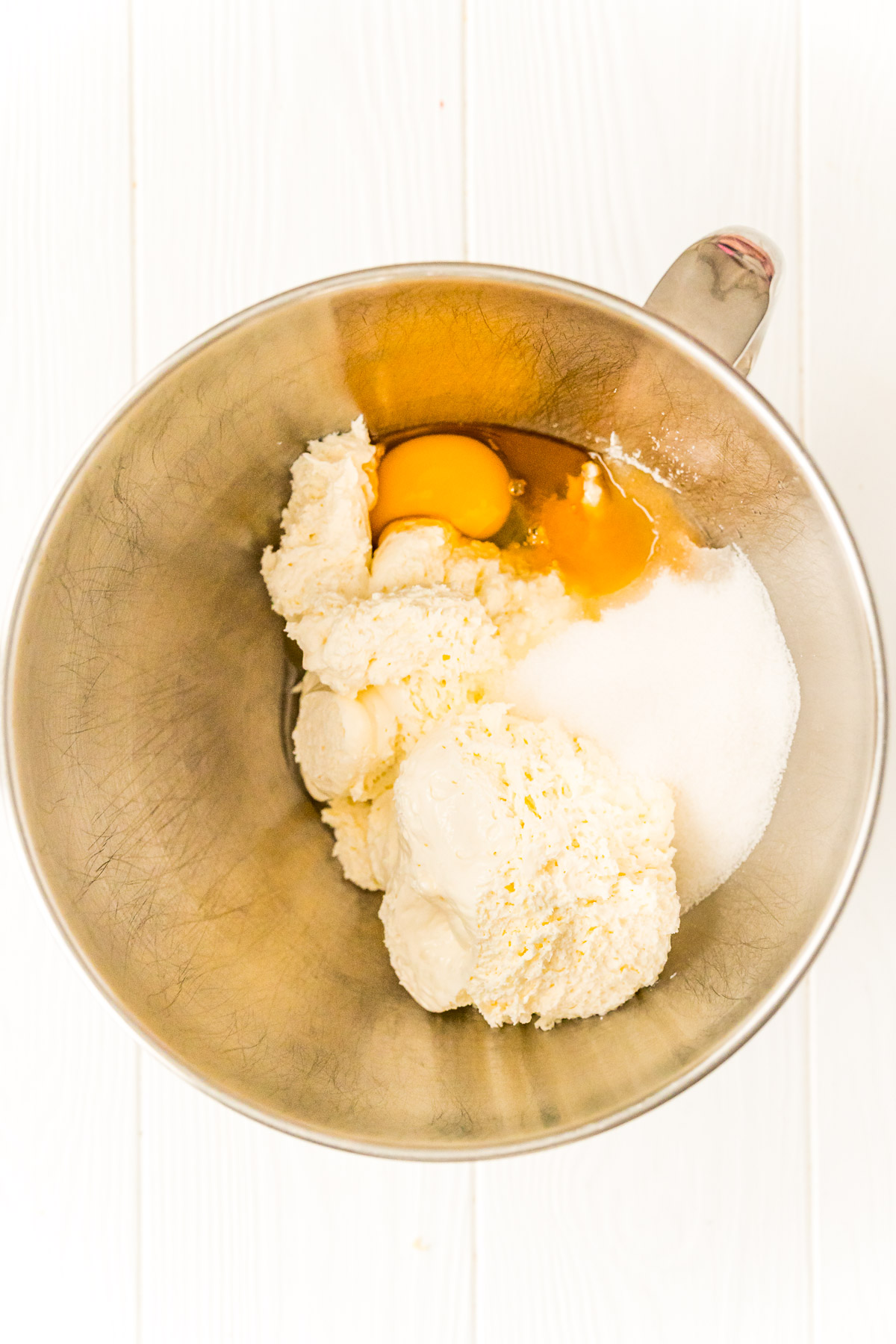 Ingredients to make a cheesecake filling in a mixing bowl.