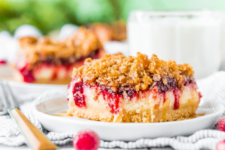 Close up photo of cranberry cheesecake bars with a bite taken out of it.