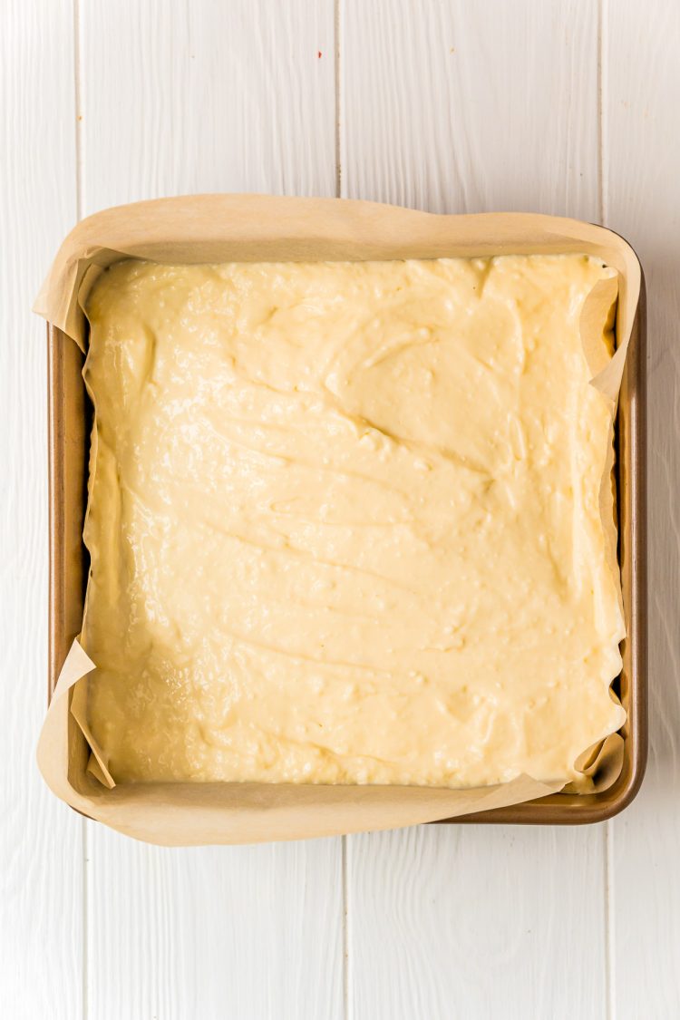 Cheesecake filling in a square baking pan to make cheesecake bars.