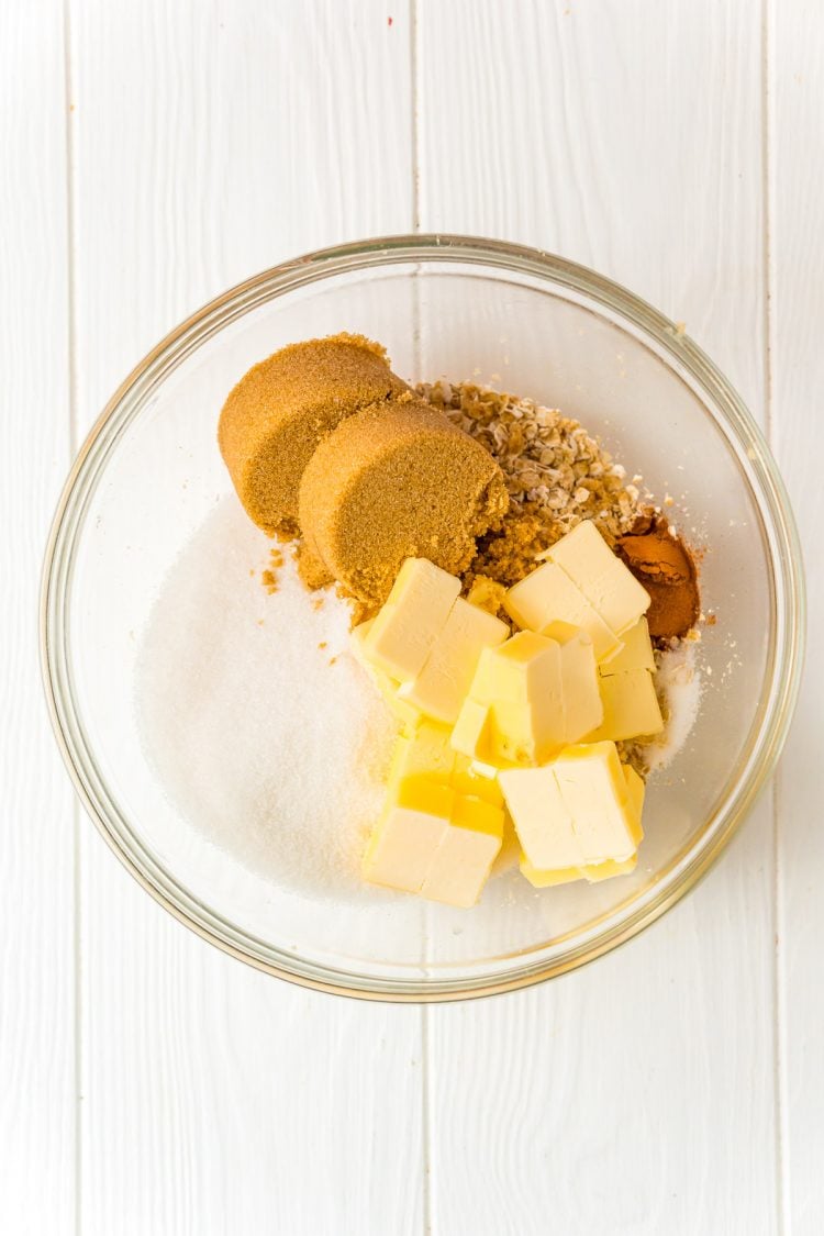 Ingredients to make an oatmeal crumble topping in a large glass bowl.