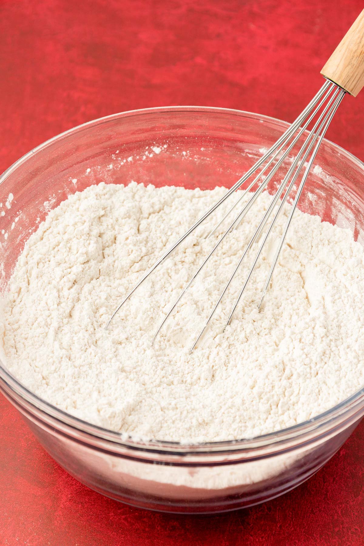 Dry ingredients being whisked in a glass bowl.