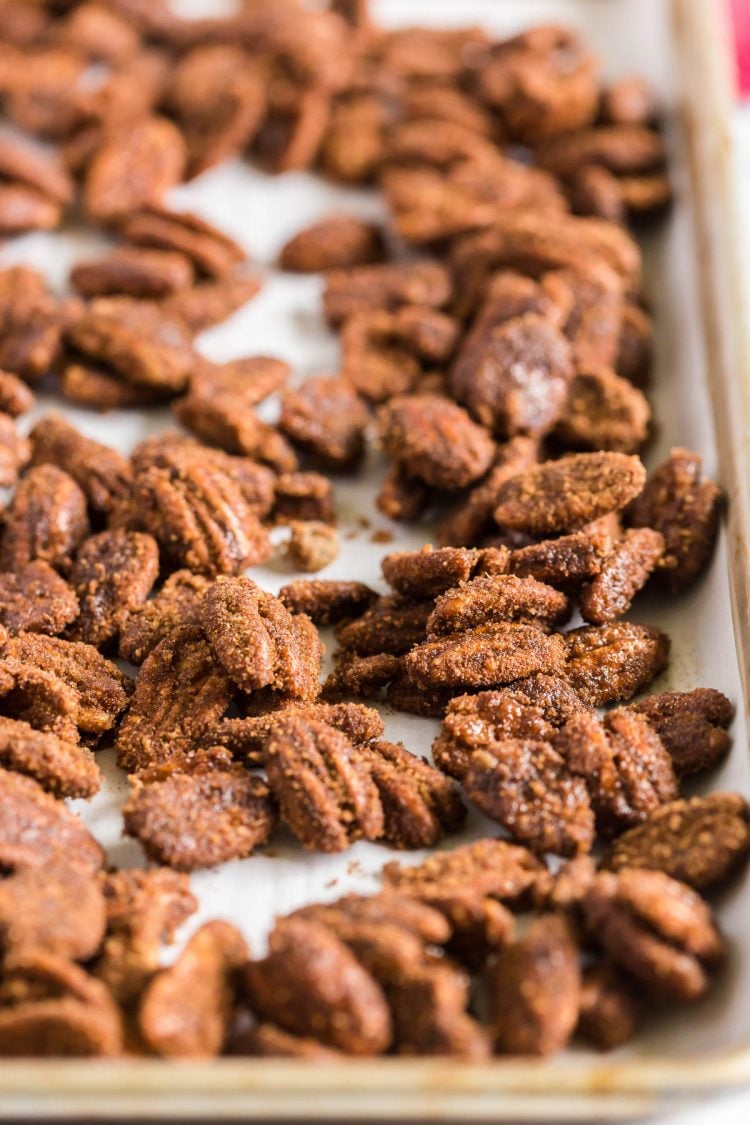 Candied pecans scattered on a baking pan.