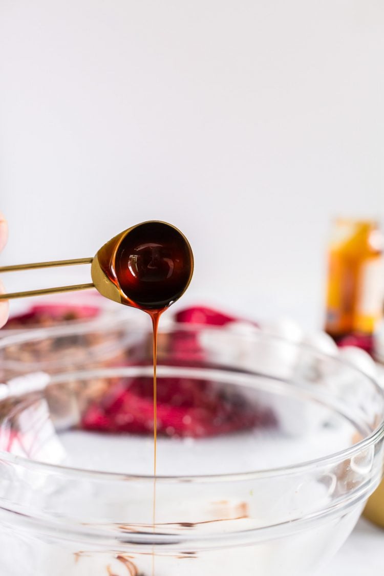 Molasses being added to a glass mixing bowl.