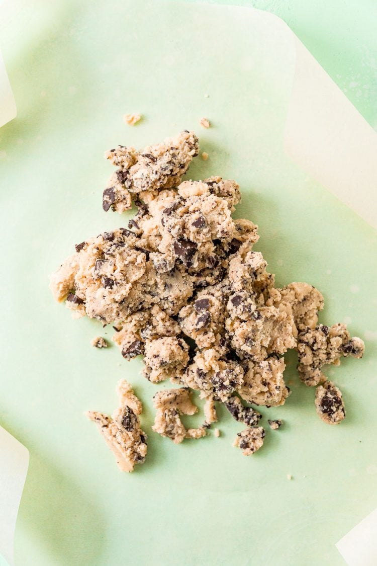 Crumbly cookie dough on parchment paper.