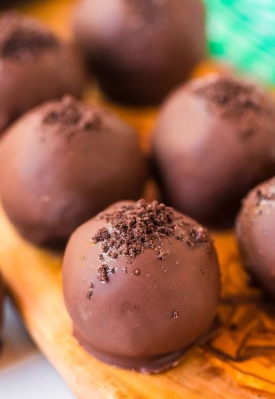 Close up photo of mint chocolate truffles on a wooden cutting board.