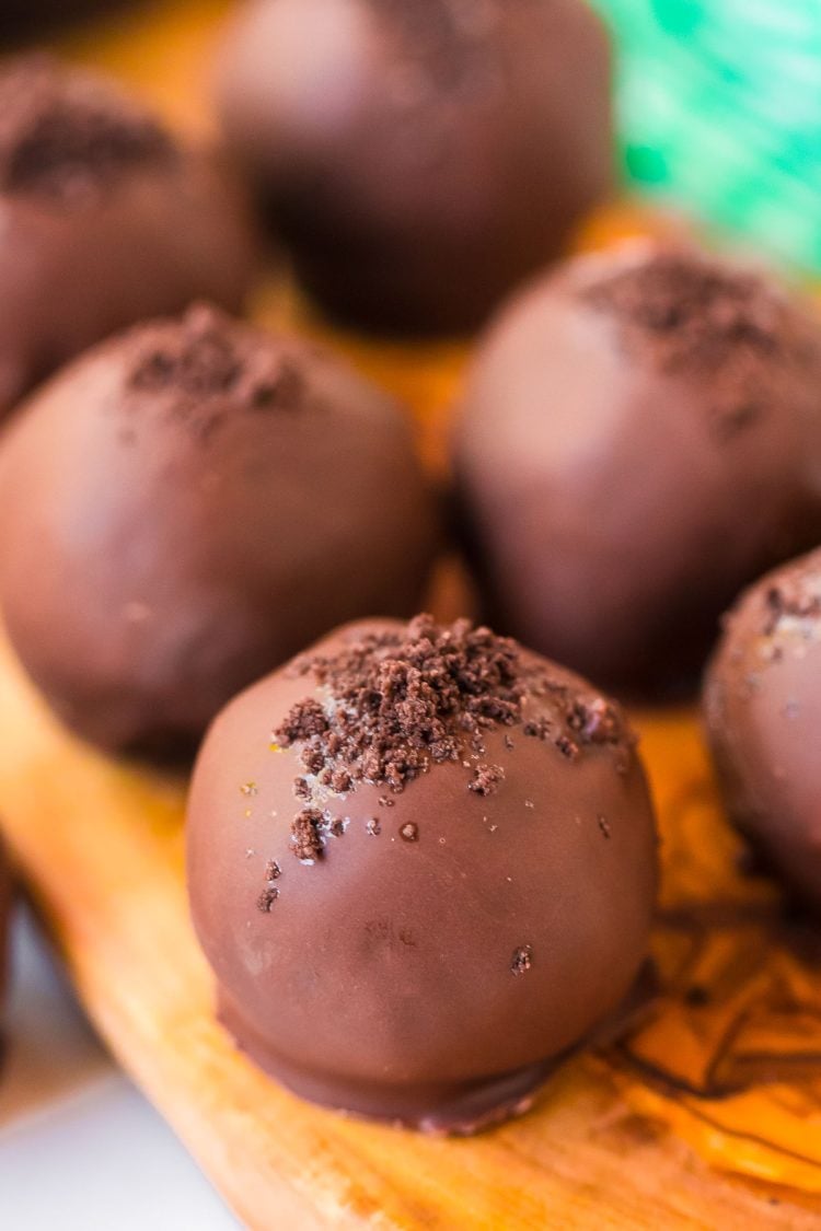 Close up photo of mint chocolate truffles on a wooden cutting board.