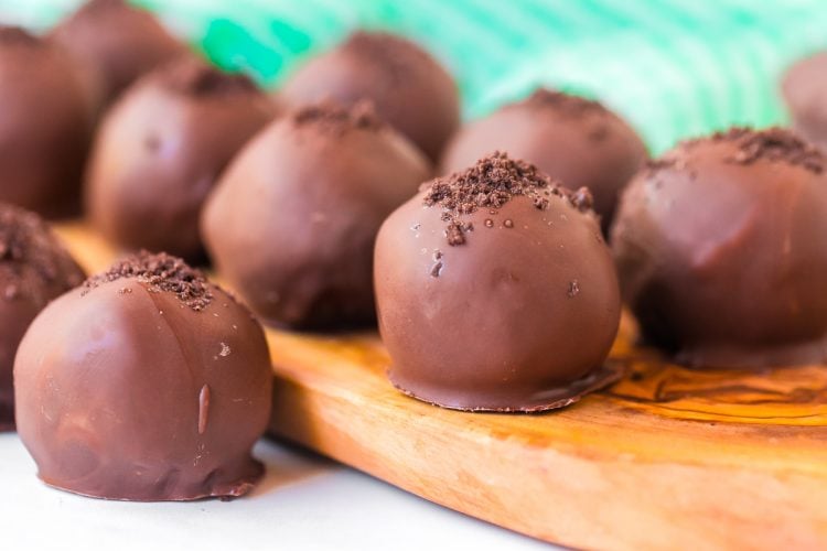 Mint cookie truffles on a wooden cutting board.