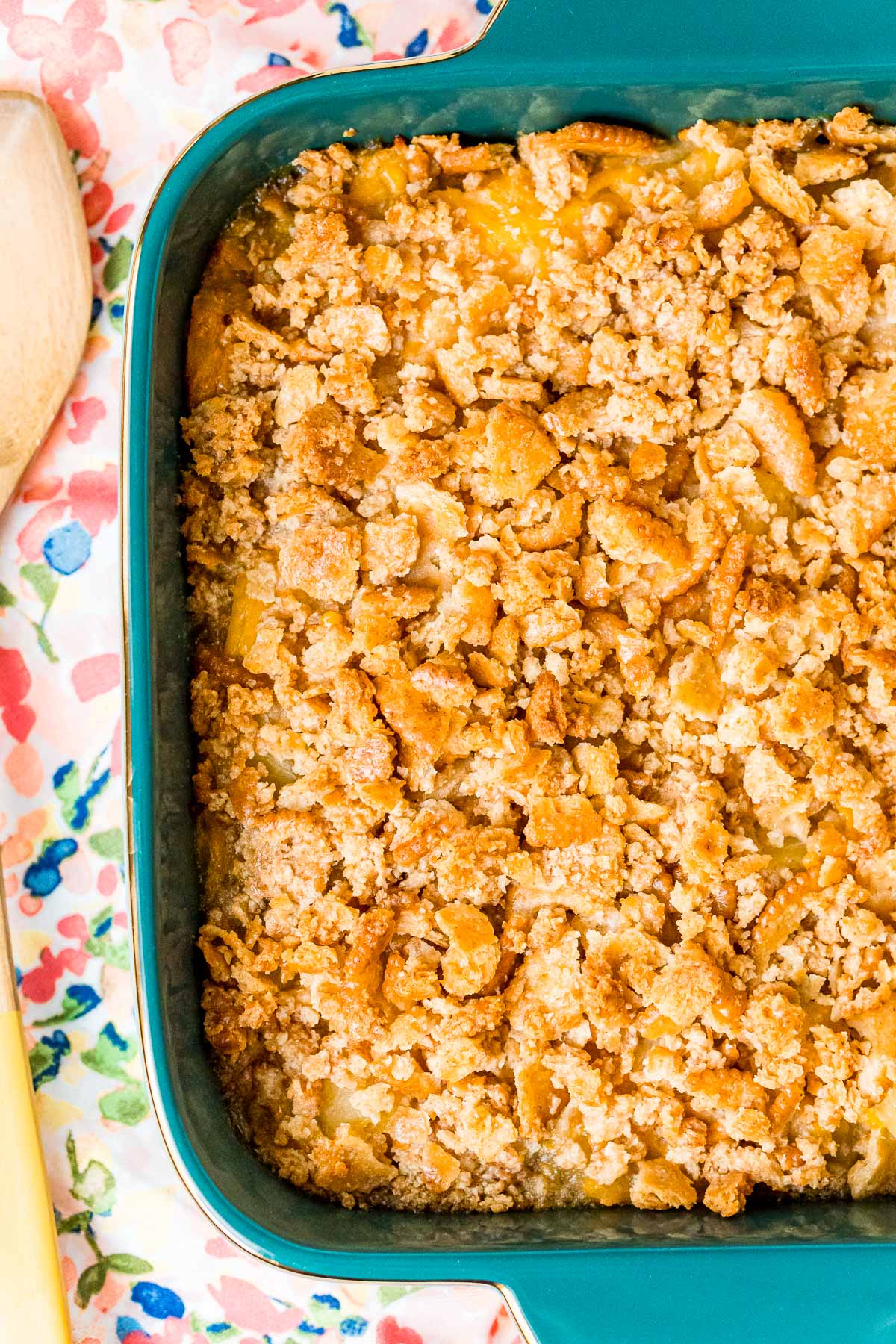 Close up overhead photo of pineapple casserole in a teal baking dish.