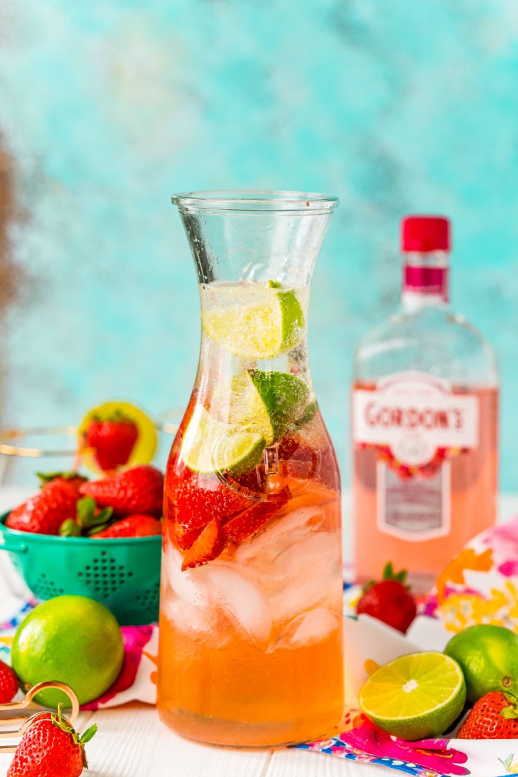 A carafe filled with a fruity pink cocktail.