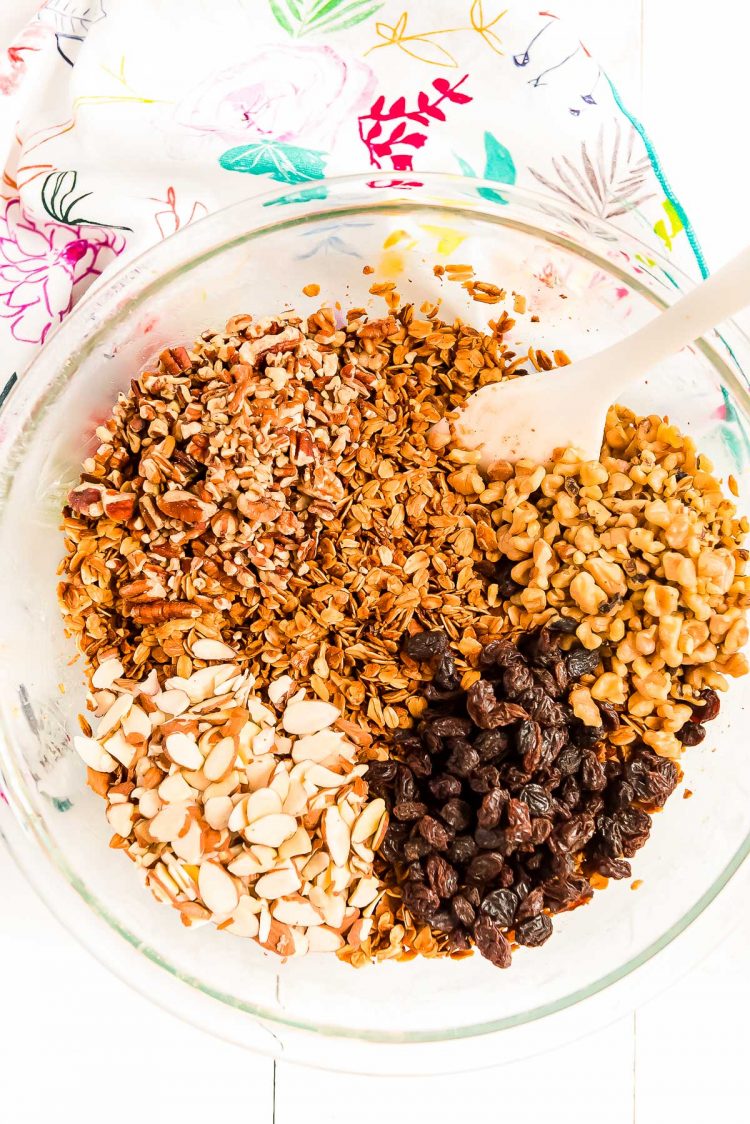 Nuts and raisins being added to toasted oats to make granola.