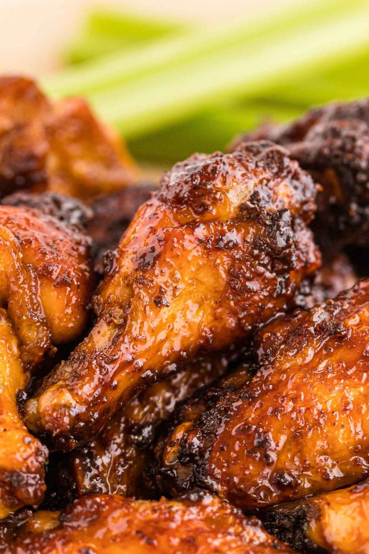 Close up photo of chicken wings with a sticky sauce on them.