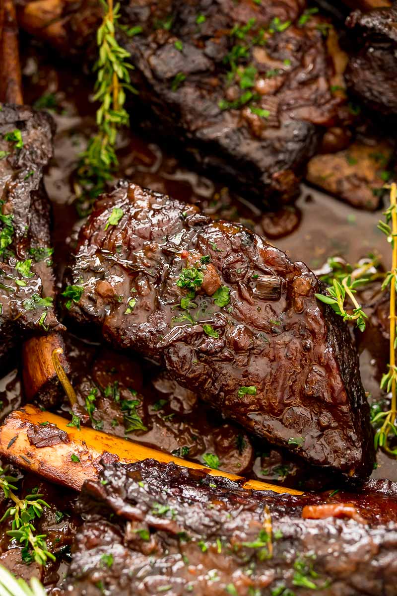 Braised beef short ribs in a pan with sauce.