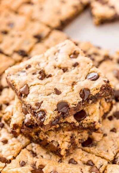 A stack of chocolate chip pan cookies on top of the rest of the pan of cookies.