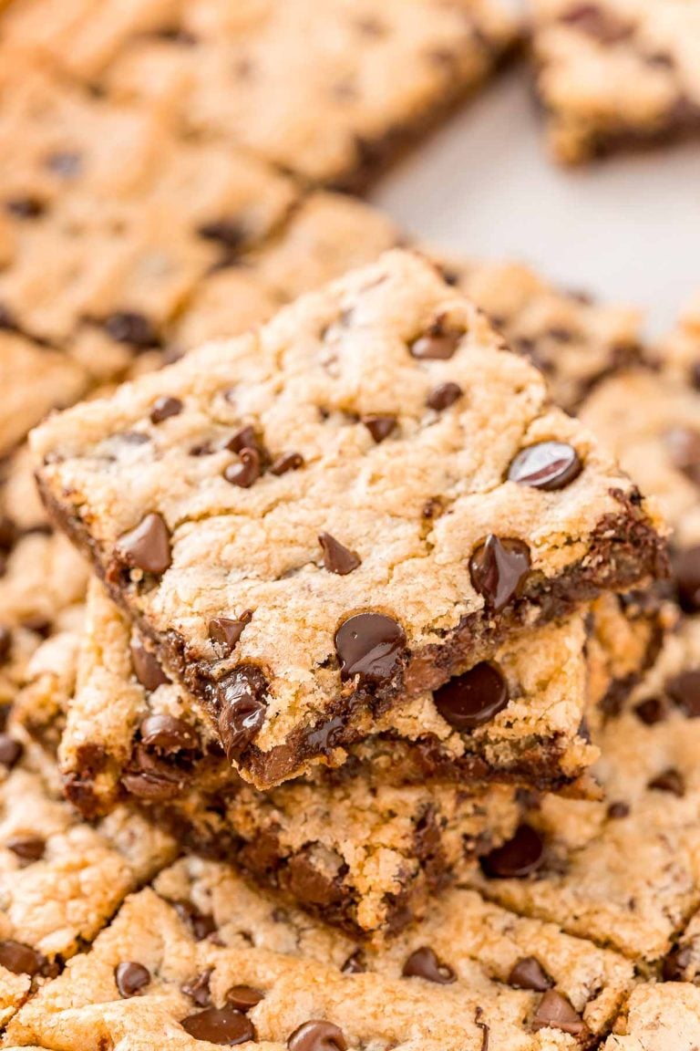 A stack of chocolate chip pan cookies on top of the rest of the pan of cookies.